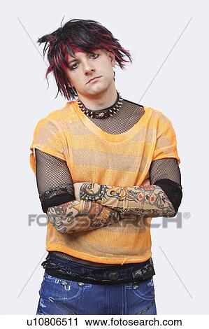 Portrait of young punk man standing with arms crossed over white background View Large Photo Image Stock Image - Portrait of young punk man standing with arms crossed over white background. Fotosearch