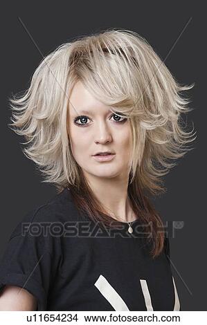 Portrait of young woman with modern hairstyle over black background View Large Photo Image Picture - Portrait of young woman with modern hairstyle over black background. Fotosearch