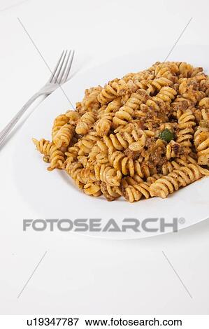 Spicy twisted pasta in plate over white background View Large Photo Image Stock Photo - Spicy twisted pasta in plate over white background. Fotosearch