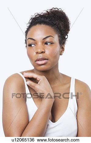Stock Photograph - Thoughtful African American young woman looking away over white background. Fotosearch