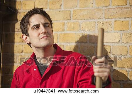 Thoughtful young male street sweeper looking away View Large Photo Image Stock Image - Thoughtful young male street sweeper looking away. Fotosearch