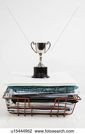 Trophy over stack of folders against white background View Large Photo Image Stock Image - Trophy over stack of folders against white background. Fotosearch