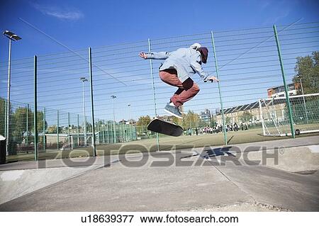 Young man skateboarding and doing Ollie View Large Photo Image Stock Photo - Young man skateboarding and doing Ollie. Fotosearch
