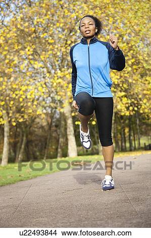 Young woman jogging in park View Large Photo Image Picture - Young woman jogging in park. Fotosearch