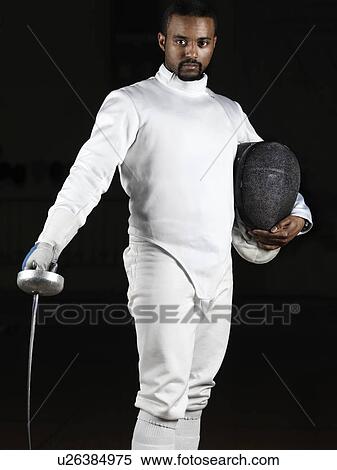 Portrait De A Escrimeur Porter Escrime Uniforme Et Tenue Une Epee Et A Masque Isole Sur Arriere Plan Noir Banques De Photographies U Fotosearch