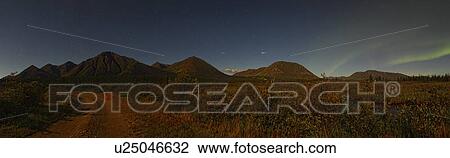 Vue Panoramique De éclairé Par La Lune Montagnes Près Whitehorse à Aurore Et étoile Filante Dans Nuit Sky Banque Dimage