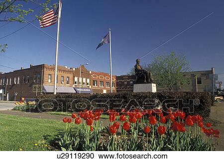 Stock Image -  Abraham Lincoln, Kentucky, Red tulips adorn the public square in the spring where the Statue of Abraham Lincoln is seated in Hodgenville in the state of Kentucky . Fotosearch