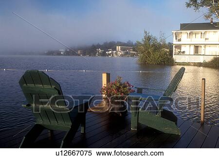 Stock Photography -  adirondack chair, Lake Placid, Adirondacks, Adirondack Park, New York, Adirondack chairs on the dock of Mirror Lake Inn facing Mirror Lake in Lake Placid in the state of New York. . Fotosearch