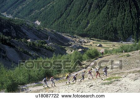 Stock Image -  Alps, hiking, France, Europe, A group of hikers walking along the GR5 trail through a rocky field in Col de Fromage in the French Alps in Hautes-Alpes.. Fotosearch