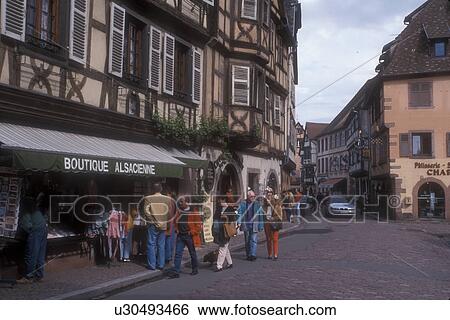 Stock Photograph -  Alsace, France, Kaysersberg, Europe, People shopping in boutiques in the picturesque village of Kaysersberg with its half-timbered houses that line the narrow cobbled streets, a wine growing village of Alsace, France. . Fotosearch