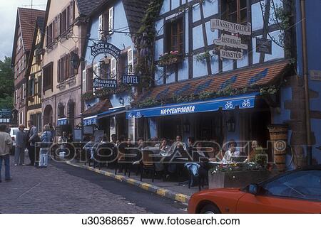 Alsace, outdoor cafe, France, Kaysersberg, Europe, People sitting at an outdoor cafe in the picturesque village of Kaysersberg with its half-timbered houses that line the narrow cobbled streets, a wine growing village of Alsace, France. View Large Photo Image Stock Photo - Alsace, outdoor cafe, France, Kaysersberg, Europe, People sitting at an outdoor cafe in the picturesque village of Kaysersberg with its half-timbered houses that line the narrow cobbled streets, a wine growing village of Alsace, France. . Fotosearch