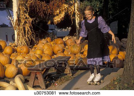 Amish, pumpkins, Pennsylvania, Lancaster County, Intercourse, A Amish girl wearing a purple dress with a black apron rollerskates in front of a pumpkin pile in the fall in Lancaster County. View Large Photo Image Stock Image - Amish, pumpkins, Pennsylvania, Lancaster County, Intercourse, A Amish girl wearing a purple dress with a black apron rollerskates in front of a pumpkin pile in the fall in Lancaster County. . Fotosearch
