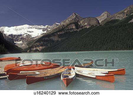 Banff National Park, canoe, Lake Louise, Alberta, Canada, Canadian Rockies, Rocky Mountains, Red and white canoes moored on the dock on beautiful Lake Louise with the snow-capped mountains in the distance in Banff National Park in the province of Alberta View Large Photo Image Stock Photo - Banff National Park, canoe, Lake Louise, Alberta, Canada, Canadian Rockies, Rocky Mountains, Red and white canoes moored on the dock on beautiful Lake Louise with the snow-capped mountains in the distance in Banff National Park in the province of Alberta. Fotosearch