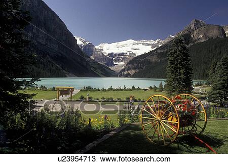 Banff National Park, Lake Louise, Alberta, Canada, Canadian Rockies, Rocky Mountains, Picturesque view of beautiful Lake Louise with the snow-capped mountains in the distance in Banff National Park in the province of Alberta. Two wheeled cart with flower View Large Photo Image Stock Image - Banff National Park, Lake Louise, Alberta, Canada, Canadian Rockies, Rocky Mountains, Picturesque view of beautiful Lake Louise with the snow-capped mountains in the distance in Banff National Park in the province of Alberta. Two wheeled cart with flower. Fotosearch