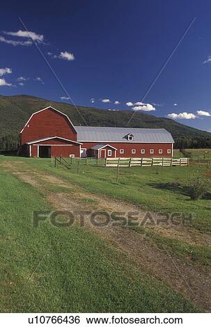 Stock Photograph -  barn, farm, Vermont, Red barn in scenic setting with blue sky and white clouds in Waterbury Center in Washington County in the state of Vermont. . Fotosearch