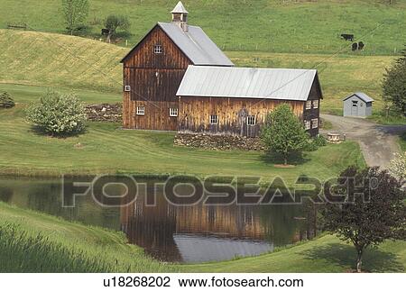 Stock Image -  barn, farm, Vermont, VT, Scenic view of the brown barn reflecting in the pond on Sleepy Hollow Farm in Pomfret in the spring.. Fotosearch