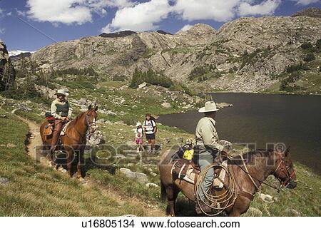 Picture -  Bighorn National Forest, horseback riding, Wyoming, Bighorn Mountains, rangersTwo rangers on horseback talk to mother and daughter backpacking in the Cloud Peak Wilderness Area in Bighorn National Forest in the state of Wyoming. . Fotosearch
