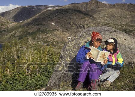 Stock Photography -  Bighorn National Forest, Wyoming, Bighorn Mountains, mother &and daughter, Mother reads a book to her daughter (6 years old) after a long day of hiking in the Cloud Peak Wilderness Area in Bighorn National, Forest in the state of Wyoming. . Fotosearch