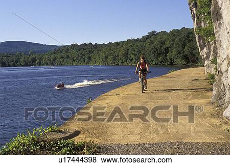 biking, bicycle, Maryland, Potomac River, Chesapeake and Ohio Canal Trail, Woman biking along the Potomac River on the recreation trail at the Chesapeake and Ohio Canal National Historic Park in the state of Maryland. Jet ski cruising along the river. View Large Photo Image Stock Photo - biking, bicycle, Maryland, Potomac River, Chesapeake and Ohio Canal Trail, Woman biking along the Potomac River on the recreation trail at the Chesapeake and Ohio Canal National Historic Park in the state of Maryland. Jet ski cruising along the river.. Fotosearch