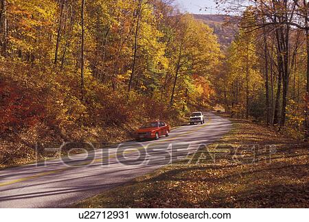 Stock Image -  Blue Ridge Parkway, autumn, road, Virginia, Blue ridge, Blue Ridge Mountains, Appalachian Mountains, Cars drive along the scenic Blue Ridge Parkway in the fall through the Jefferson National Forest in the state of Virginia.. Fotosearch