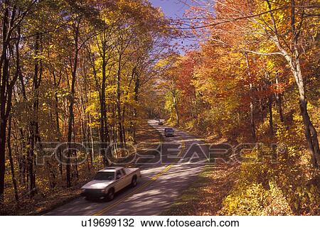 Stock Image -  Blue Ridge Parkway, Blue Ridge, autumn, road, Virginia, Blue Ridge Mountains, Appalachian Mountains, A pick-up truck and cars drive on the scenic Blue Ridge Parkway in the fall through the Jefferson National Forest in the state of Virginia.. Fotosearch