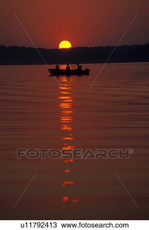 Stock Image -  boat, sunset, fishing, Kentucky Lake, Kentucky, Men fishing in a boat as the [sunsets, sunrises] over Land Between the Lakes National Recreation Area.. Fotosearch