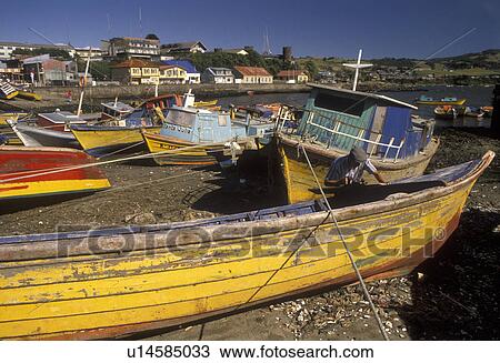 boats, Chile, Chiloe Island, Colorful fishing boats beached at low tide in the harbor in Ancud on the Pacific Ocean on Chiloe Island in Chile. Local man repairing yellow fishing boat on the beach. View Large Photo Image Stock Image - boats, Chile, Chiloe Island, Colorful fishing boats beached at low tide in the harbor in Ancud on the Pacific Ocean on Chiloe Island in Chile. Local man repairing yellow fishing boat on the beach.. Fotosearch