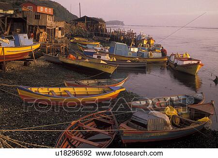 Stock Image -  boats, Chile, Chiloe Island, Colorful fishing boats beached at low tide at sunrise in the harbor in Ancud on the Pacific Ocean on Chiloe Island in Chile. . Fotosearch