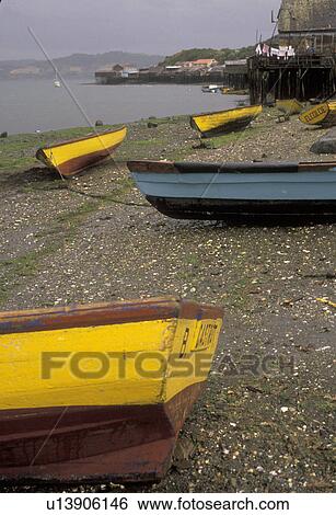 Stock Photograph -  boats, Chile, Chiloe Island, Colorful fishing boats beached at low tide on the Pacific Ocean in Castro on Chiloe Island in Chile.. Fotosearch