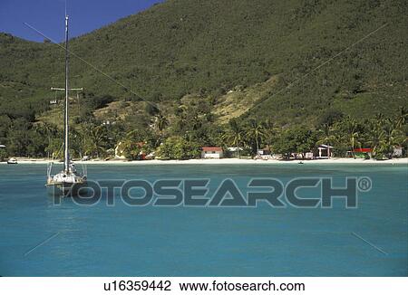 Stock Image -  British Virgin Islands, Jost Van Dyke, Caribbean, Virgin Islands, B. V. I BVI, Sailboat buoyed on the calm blue green waters of Great Harbor on the island of Jost Van Dyke on the British Virgin Islands.. Fotosearch
