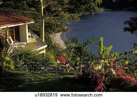 Stock Photo -  British Virgin Islands, Tortola, Caribbean, Virgin Islands, BVI, B. V. I Picturesque view of Brewer's Bay from Escape House with bougainvillea flowers on the island of Tortola on the British Virgin Islands.. Fotosearch