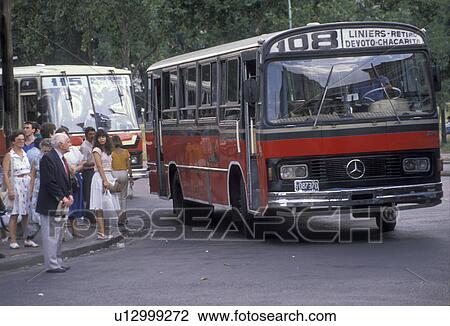 Stock Image -  bus, Buenos Aires, Argentina, People waiting on the street corner for the bus in the capital city of Buenos Aires.. Fotosearch