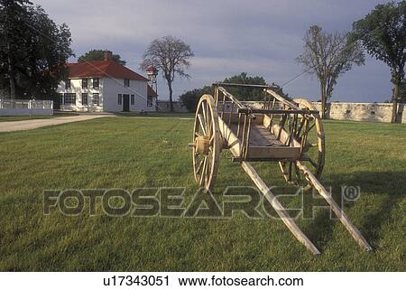 Stock Image -  Canada, Manitoba, Wooden cart is displayed on the lawn of Lower Fort Garry National Historic Site in Selkirk. The oldest intact stone fur-trading post in North America . Fotosearch