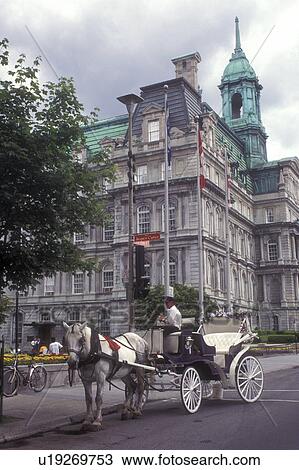 Stock Image -  Canada, Quebec, Montreal, Horse drawn carriage parked outside City Hall waiting to take tourists around Vieux Montreal.. Fotosearch