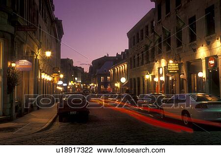 Stock Image -  Canada, Quebec, Montreal, Shops along street at night (evening) in Vieux Montreal.. Fotosearch