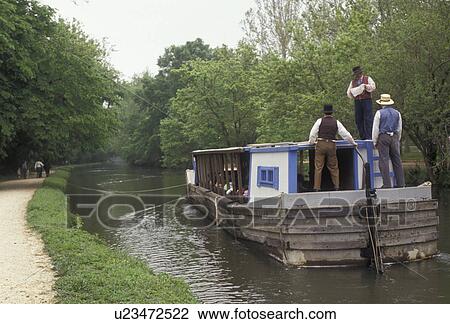 Stock Image -  canal, boat, Chesapeake and Ohio Canal National Historical Park, Great Falls Tavern, Maryland, A mule-drawn canal boat with costumed interpreters floats slowly down the Chesapeake & Ohio Canal at Great Falls Tavern in the state of Maryland.. Fotosearch