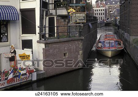 canal, tour boat, Amsterdam, Holland, Netherlands, Europe, Tour boat cruises slowly through a narrow canal in Amsterdam. View Large Photo Image Stock Photography - canal, tour boat, Amsterdam, Holland, Netherlands, Europe, Tour boat cruises slowly through a narrow canal in Amsterdam.. Fotosearch