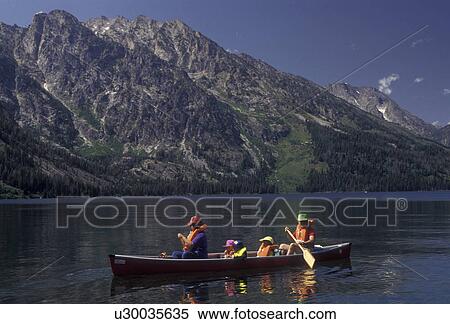 canoe, Grand Teton National Park, Lake Jenny, Grand Teton, Wyoming, Grand Teton Mountain, Rocky Mountains, A family paddles their canoe on Lake Jenny with a view of the majestic Teton Mountains behind in Grand Teton National Park in the state of Wyoming. View Large Photo Image Stock Photography - canoe, Grand Teton National Park, Lake Jenny, Grand Teton, Wyoming, Grand Teton Mountain, Rocky Mountains, A family paddles their canoe on Lake Jenny with a view of the majestic Teton Mountains behind in Grand Teton National Park in the state of Wyoming.. Fotosearch