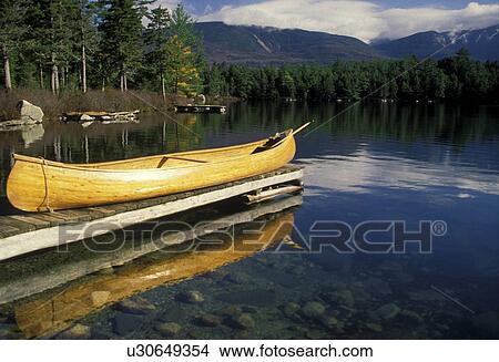 canoe, Maine, Baxter State Park, lake, A handmade wooden canoe resting on a dock reflects in the clear waters of Daicey Pond. View Large Photo Image Picture - canoe, Maine, Baxter State Park, lake, A handmade wooden canoe resting on a dock reflects in the clear waters of Daicey Pond.. Fotosearch
