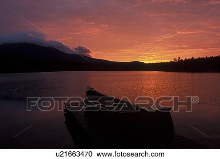 Stock Image -  canoe, sunrise, sunset, mountain, lake, Baxter State Park, Maine, Mt. Katahdin, [Sunrise, sunset] over Daicey Pond at Baxter State Park. Canoe rests on the dock of the lake.. Fotosearch