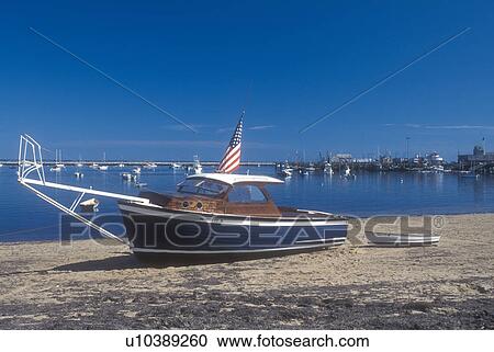Stock Image -  Cape Cod, Massachusetts, Provincetown, Boat rests on beach at low tide in Provincetown Harbor in Provincetown, Massachusetts. . Fotosearch