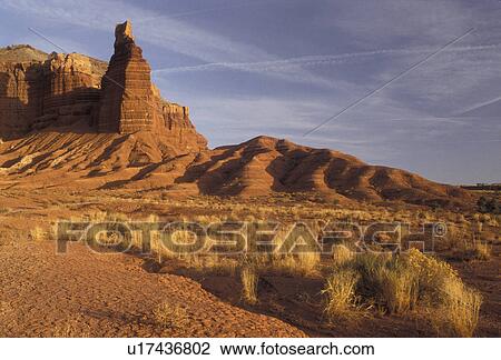 Stock Image -  Capitol Reef, Capitol Reef National Park, Utah, Chimney Rock a natural rock formation stands across a dusty field in Capitol Reef Nat'l Park in the state of Utah.. Fotosearch