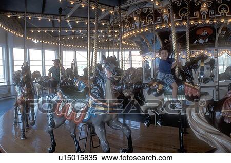 Stock Photography -  carousel, Massachusetts, Children riding on the Fall River Carousel at Battleship Cove in Fall River, Massachusetts. . Fotosearch