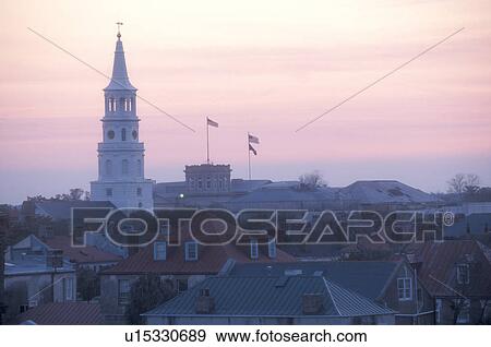 Stock Photo -  Charleston, South Carolina, The steeple of St. Michael's Episcopal Church and rooftops of the buildings at sunset in downtown Charleston, South Carolina.. Fotosearch
