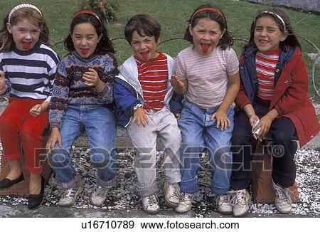 Stock Photo -  children, Chile, Chiloe Island, Local children showing their red tongues after eating powdered red candy in Achao on Chiloe Island in Chile.. Fotosearch