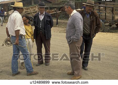 Stock Photo -  Chile, Temuco, Four local men talking with boy at the local cattle market in Temuco in the South-Central Region (Land of Lakes and Volcanoes) in Chile., . Fotosearch