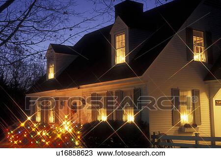 Stock Image -  Christmas, X-mas, xmas, Vermont, Colorful lights decorate a home in Montpelier at night for the holiday Christmas season in Washington County in the state of Vermont. Candle lights glow in the windows. . Fotosearch