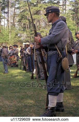 Stock Photo -  Civil War Reenactment, Confederate, Confederate soldier, Stone Mountain, Atlanta, Georgia's Stone Mountain Park, Georgia, Man dressed as Confederate Soldiers stand in formation waiting for commands from the officer during the Civil War Reenactment at the. Fotosearch