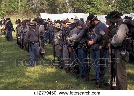 Stock Image -  Confederate soldiers, Civil War Reenactment, Confederate, Stone Mountain, Atlanta, Georgia's Stone Mountain Park, Georgia, Men dressed as Confederate Soldiers stand in line waiting for commands from officer during a Civil War Reenactment at the Antebellu. Fotosearch