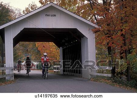 Stock Photography -  covered bridge, fall, cyclist, bike, Vermont, Montgomery, People riding bikes through Fuller Covered Bridge (circa 1890) surrounded by fall foliage in Montgomery. . Fotosearch